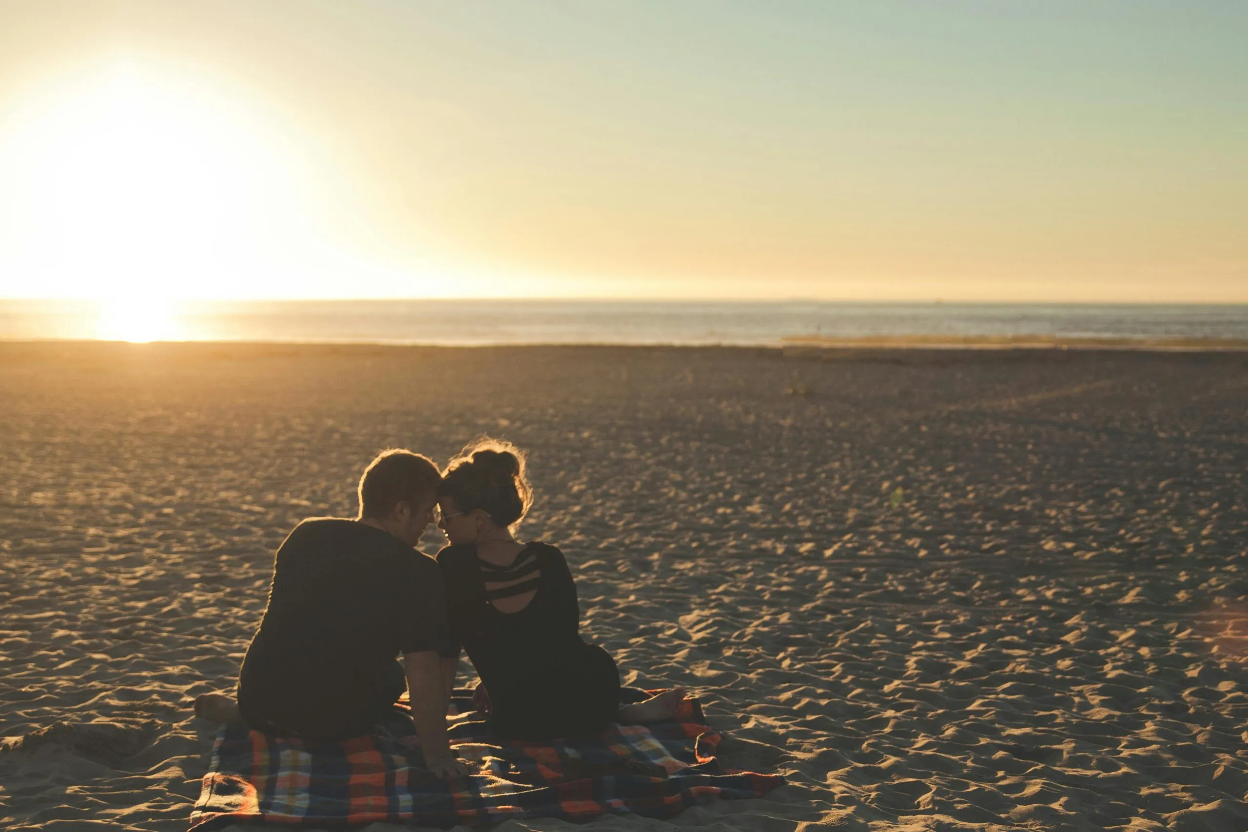 Couple watching a beach sunset representing the connection and love that comes from healthy self-development in dating