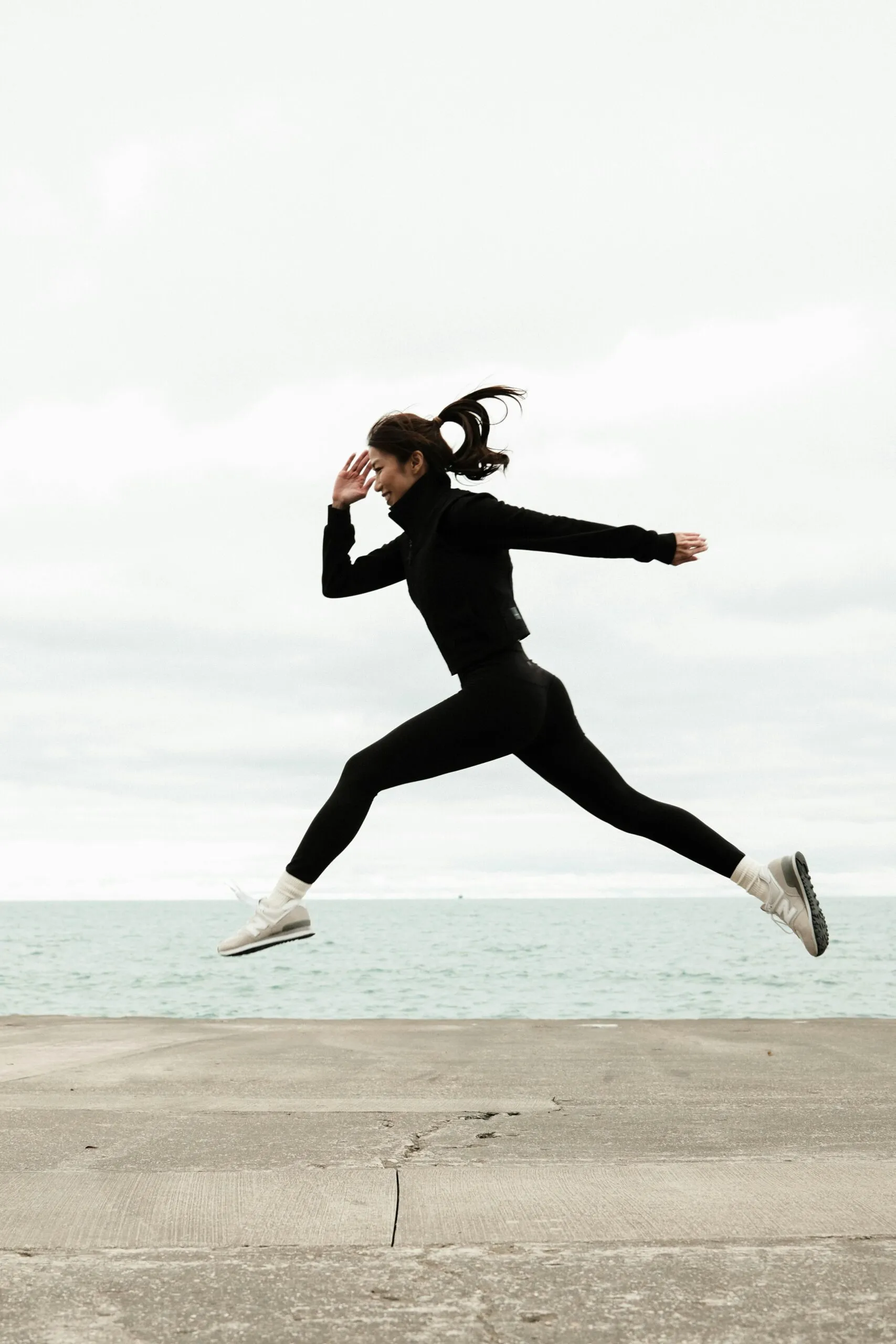 Woman jumping energetically outdoors representing healthy physical activity as a coping mechanism in porn recovery