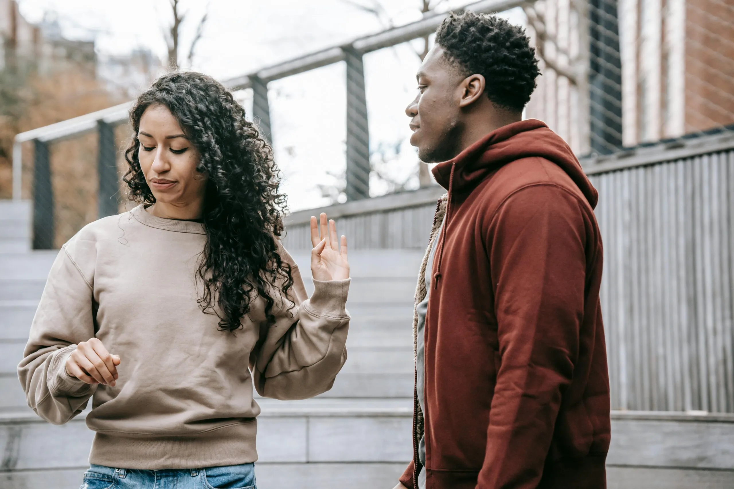Couple in a tense moment on the street representing the negative interaction cycle in couples therapy after betrayal trauma