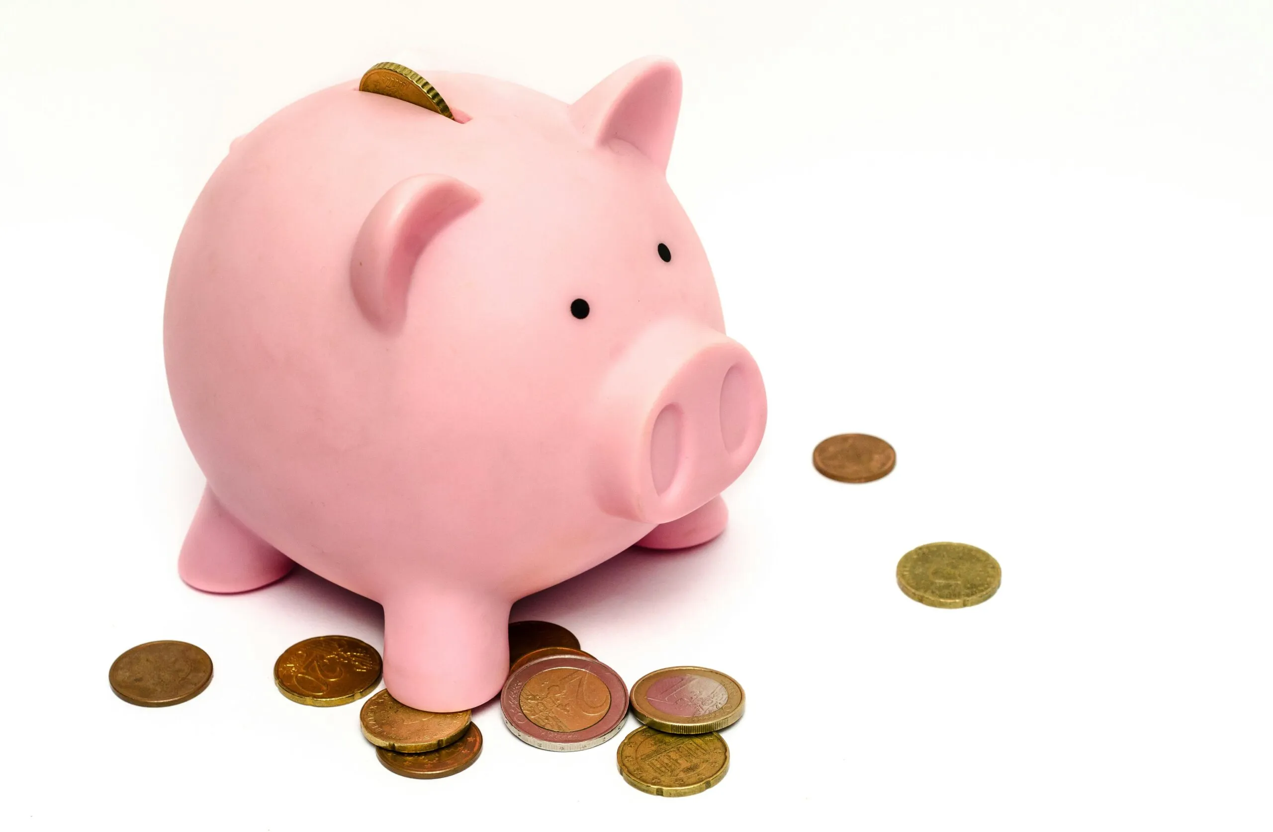 Pink piggy bank with coins representing financial stress and the emotional relationship with money in couples