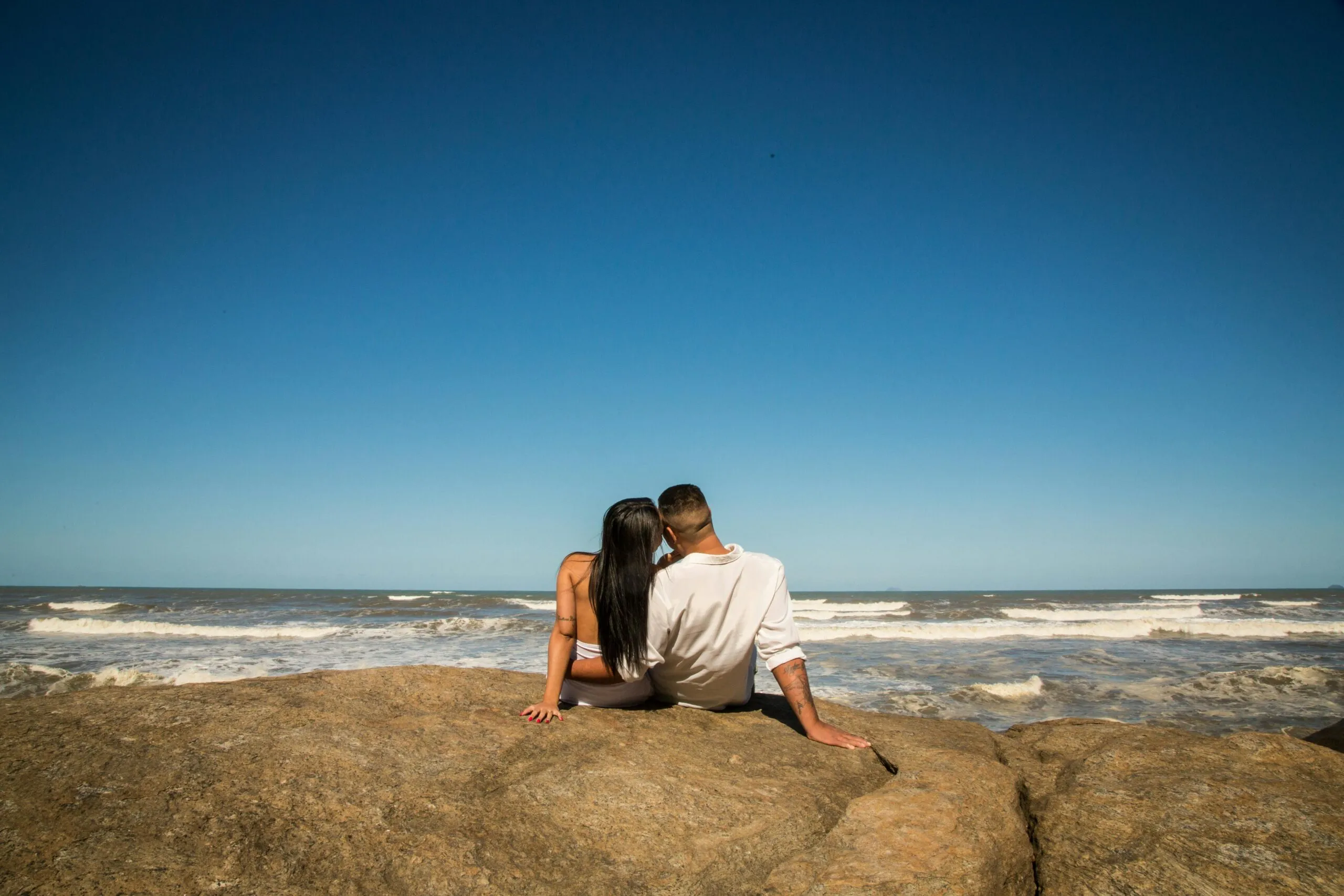 Couple walking together along a coastal path representing attunement and emotional reconnection after betrayal trauma