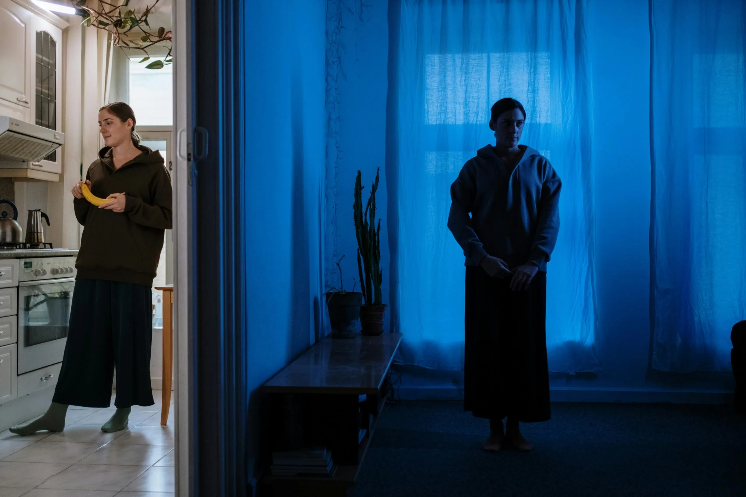 Woman standing in a dimly lit room representing the emotional complexity of living with bipolar disorder in family relationships