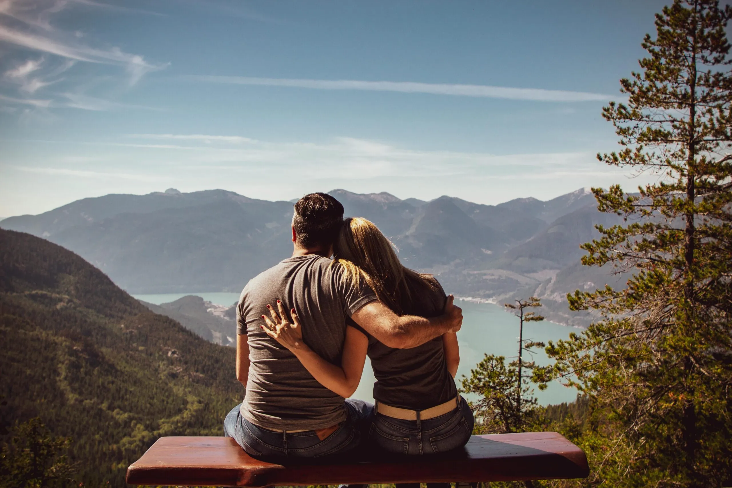 Couple sitting together on a bench with a scenic view representing emotional reconnection and healthy intimacy in relationships