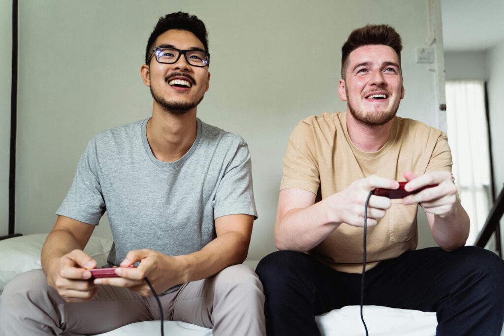 Two friends enjoying video games together at home, laughing and having fun.