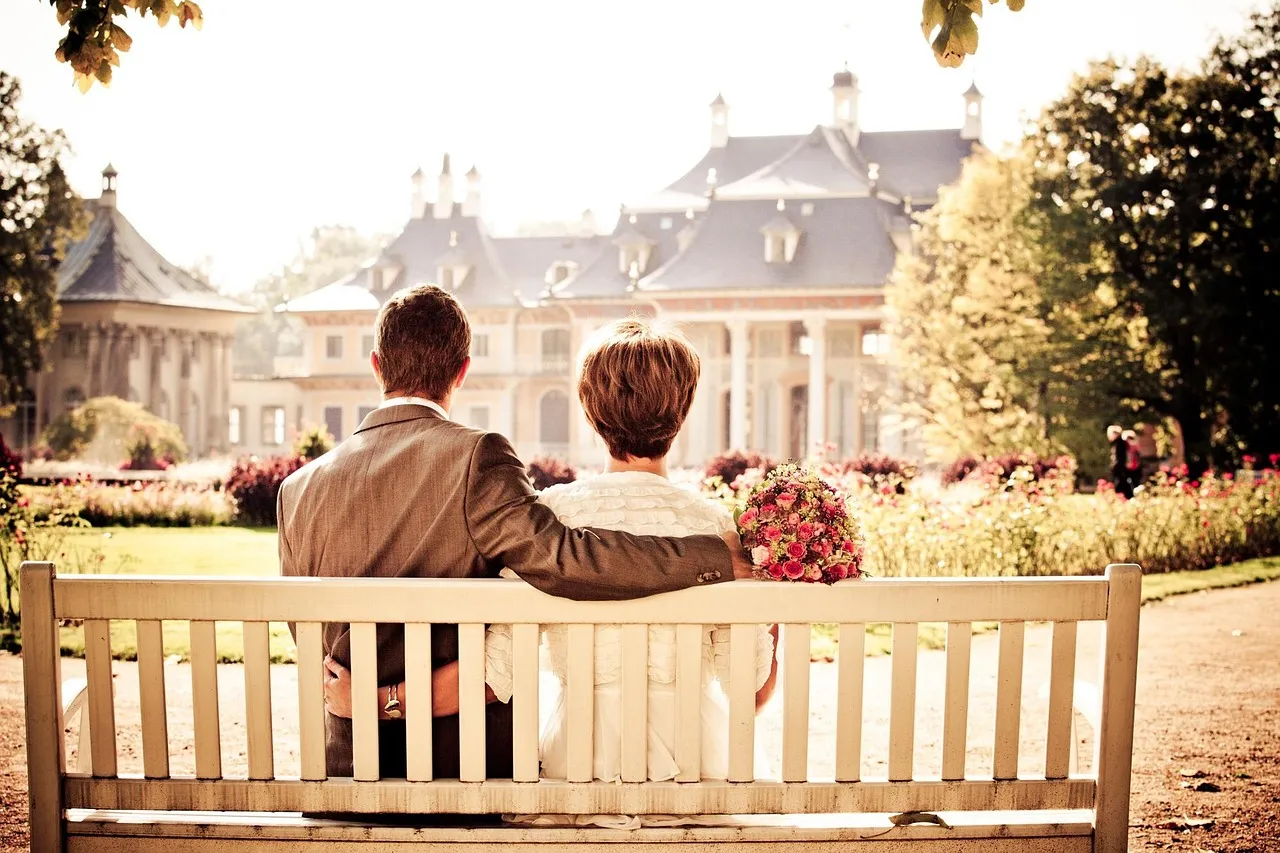 Married couple sitting together on a bench representing connection during different growth seasons in a relationship