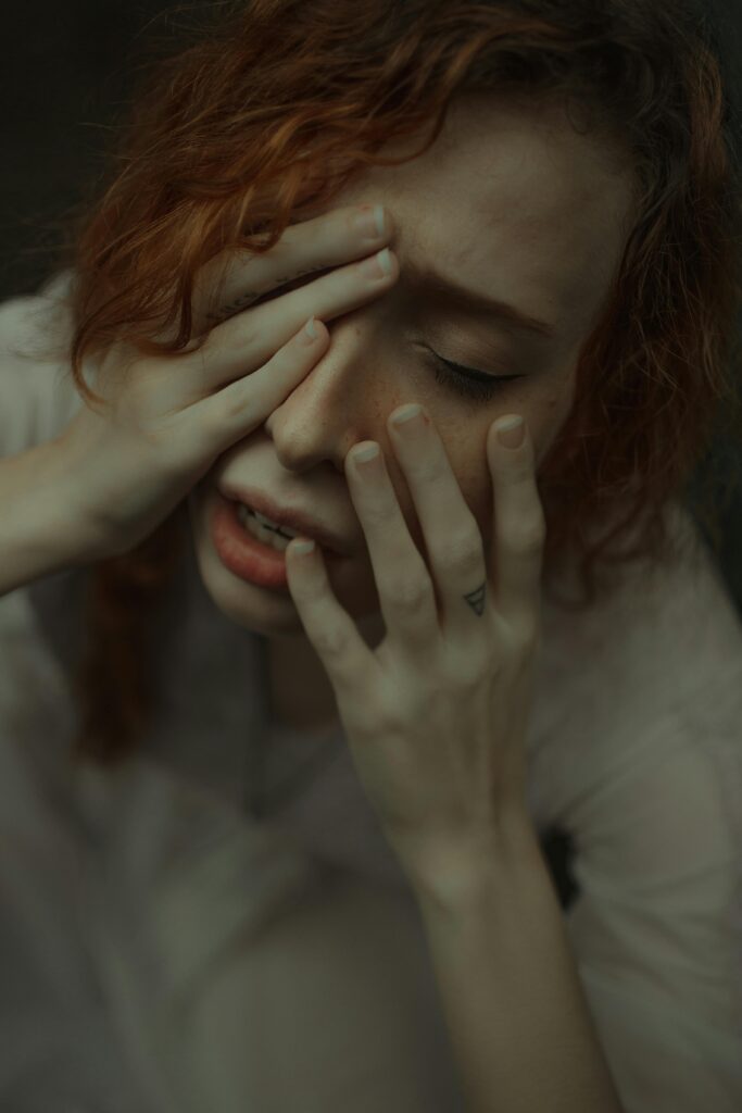 A close-up shot of a woman expressing deep emotional distress and anxiety.