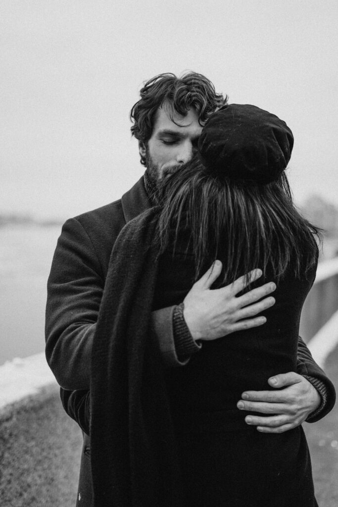 A couple shares an intimate embrace in a black and white photo, conveying love and togetherness.