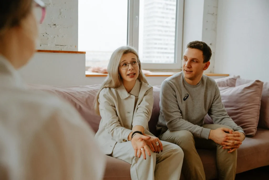 Couple discussing relationship concerns with therapist in office setting