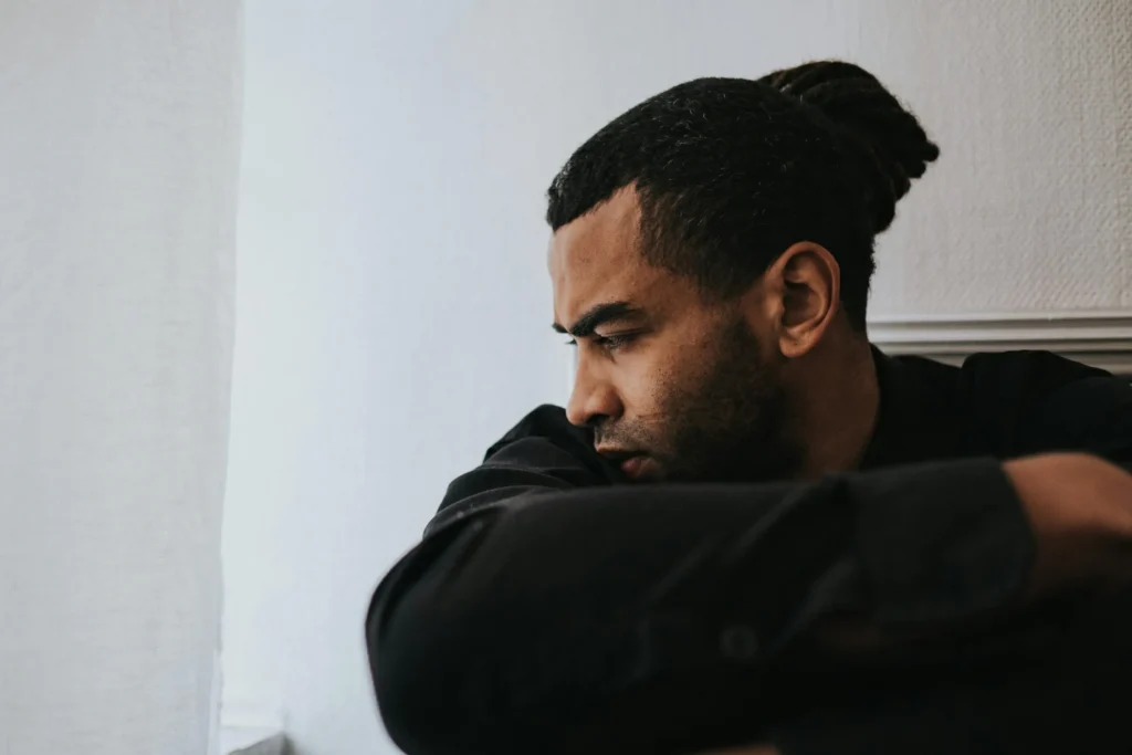 Man sitting alone in deep thought reflecting on compulsive pornography use — pornography addiction therapy Utah